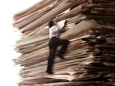 A Picture of a small person climbing a stack of papers